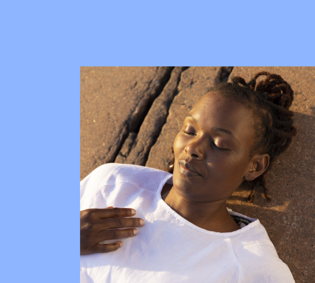 Woman laying down on stone with smile